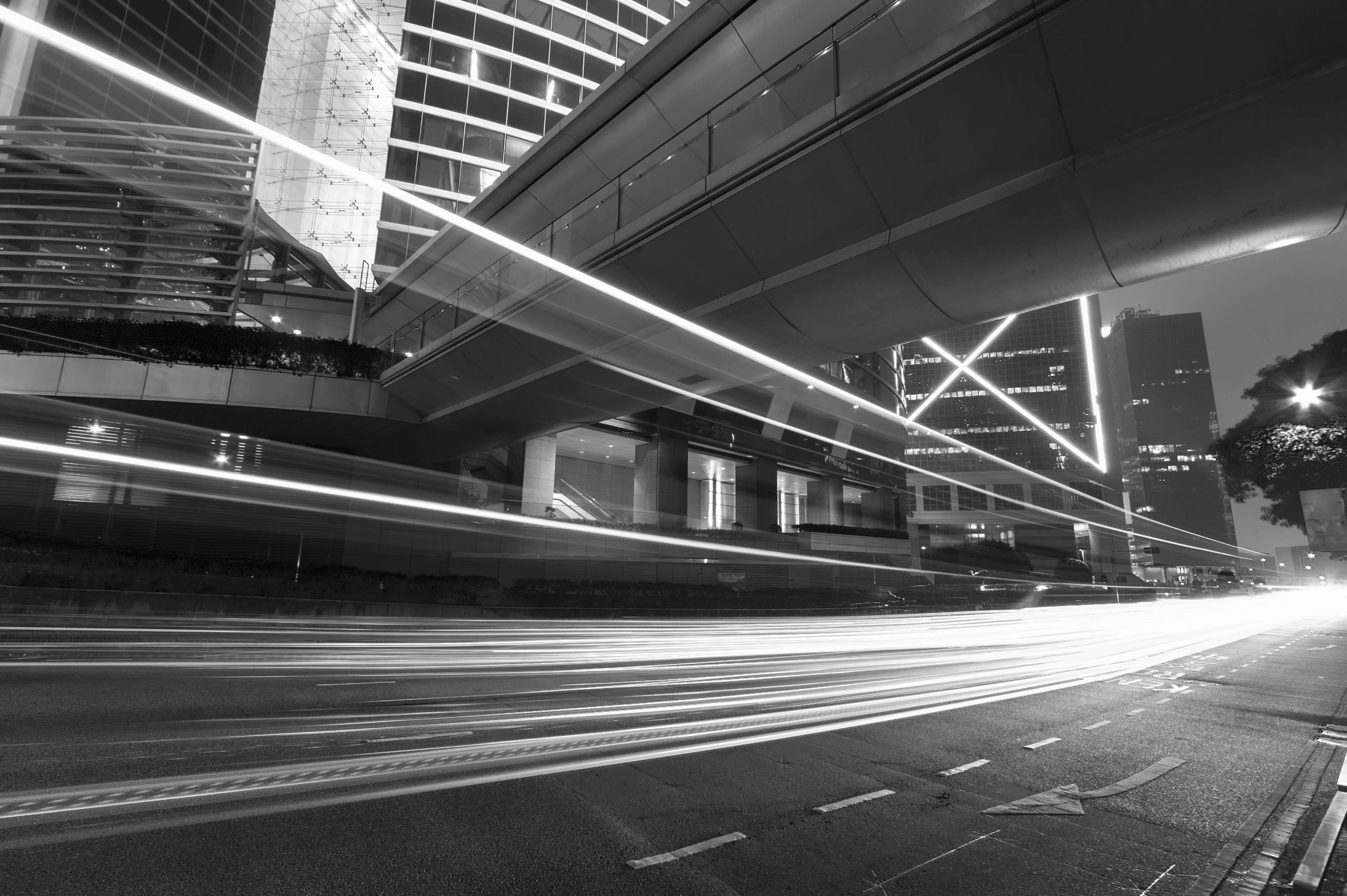 A black and white photo of a street with lights